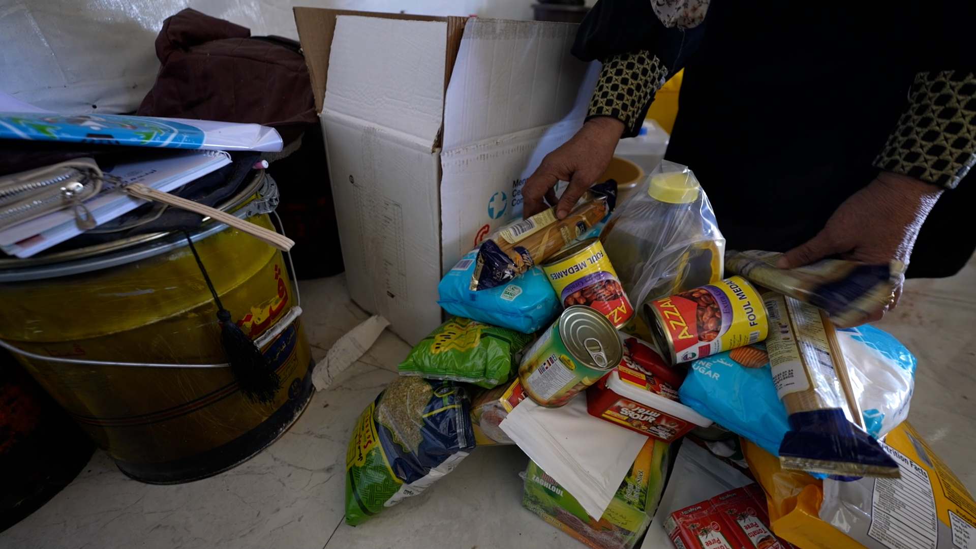 pile of canned goods and other packaged food on floor